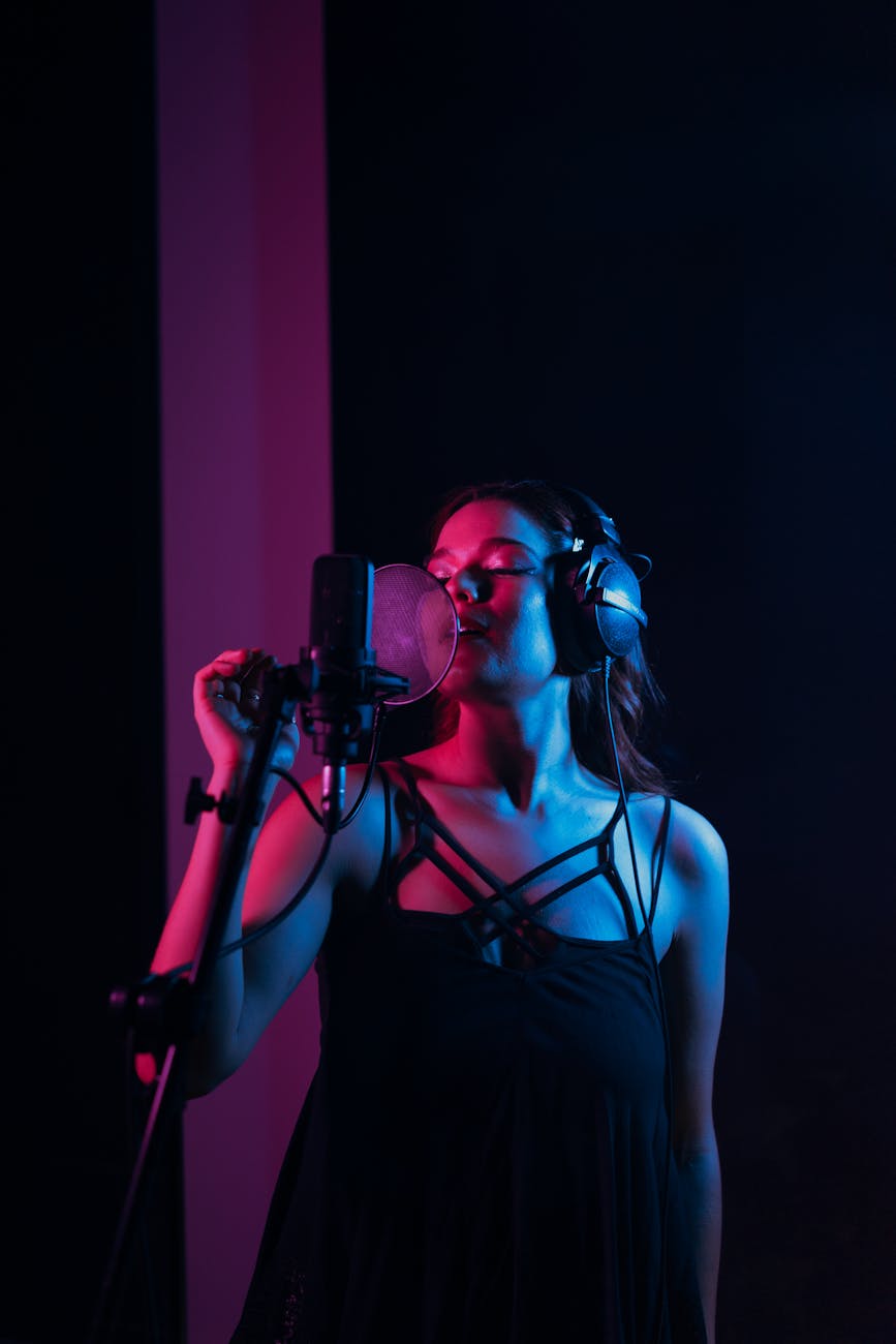 photo of a woman singing in a recording studio with her eyes closed